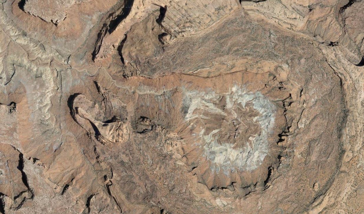 As seen in this satellite view, the rim of Upheaval Dome is 3 miles across and over 1,000 feet above the core floor. The central peak in the core is 3,000 feet in diameter and rises 750 feet from the floor. Since the late 1990s, the origin of the Upheaval Dome structure has been considered to be either a pinched-off salt dome or a complex meteorite impact crater. In 2007, German scientists reported finding quartz crystals that were “shocked” by the high pressure of a meteorite impact. Many geologists now consider the mystery of Upheaval Dome’s origin to be solved.